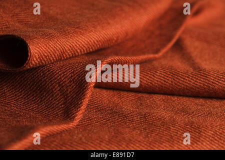 Close-up di ripiegata di colore arancione scuro sciarpa panno con texture setosa Foto Stock