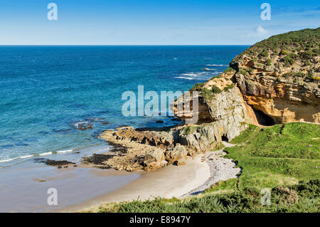 Linea costiera di Moray Scozia vicino HOPEMAN GOLDEN scogliere di arenaria con le grotte SPIAGGIA E MARE Foto Stock