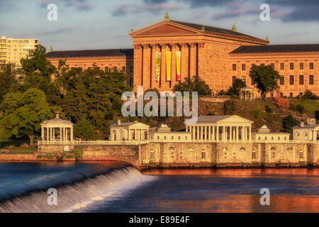 Philadelphia Museum of Art - Vista a ovest del Philadelphia Museum of Art durante la magica ora del tramonto. La calda luce dorata del sole tramonta si riflette nell'architettura, nel Fairmount Park e nelle acque del Fairmount Water Works sulla diga del fiume Schuylkill in primo piano. Il Philadelphia Museum of Art è uno dei più grandi musei d'arte degli Stati Uniti. Oltre ad essere noto per la sua architettura e le sue collezioni, il Philadelphia Museum of Art è anche conosciuto per il ruolo che ha interpretato nei film Rocky - Rocky (1976) e quattro dei suoi cinque sequel, II, III, V e Rocky Balboa Foto Stock