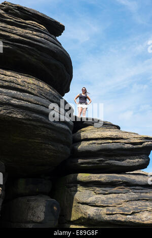 Rambler permanente sulla formazione di roccia nel Derbyshire Peak District. Foto Stock