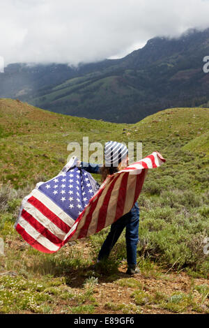 Ragazza con bandiera americana nel campo Foto Stock