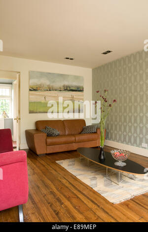 Stile retrò tabella di caffè di fronte divani in pelle marrone nella moderna sala soggiorno Foto Stock