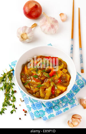 Delizioso stufato di melanzane con pomodoro e peperone, erbe aromatiche fresche, cipolla e aglio. Vista dall'alto. Foto Stock