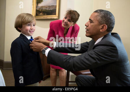 Il presidente Barack Obama regola il tirante della Guardia Costiera Aide militare CDR. Scott S. Phy del figlio al di fuori dell'Ufficio Ovale, Giugno 12, 2014. Cdr. Phy e la sua famiglia erano all Ufficio Ovale per un premio di citazione e foto di partenza con il presidente. Foto Stock