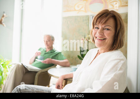 Ritratto di donna senior sorridere mentre uomo maturo in background Foto Stock