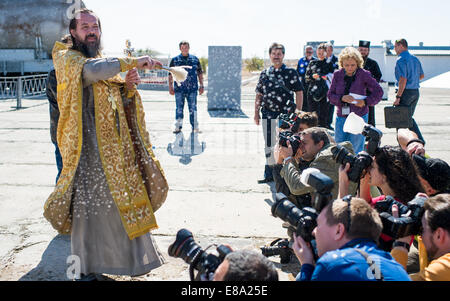 Un sacerdote ortodosso benedice i membri dei media presso il cosmodromo di Baikonur launch pad su Mercoledì, 24 settembre 2014 in Kazakistan. Lancio del razzo Soyuz è prevista per settembre 26 e invierà Expedition 41 Soyuz Commander Samokutyae Alexander Foto Stock