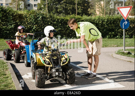 Il tutor spiegando quadbike al ragazzo su driver area formazione Foto Stock