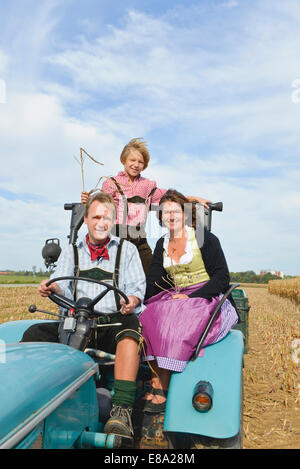 La famiglia sul trattore in cornfield, Baviera, Germania Foto Stock