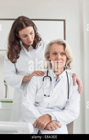 Medico donna consolante collega Foto Stock