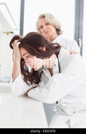 Medico donna consolante collega Foto Stock