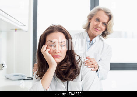 Medico donna consolante collega Foto Stock