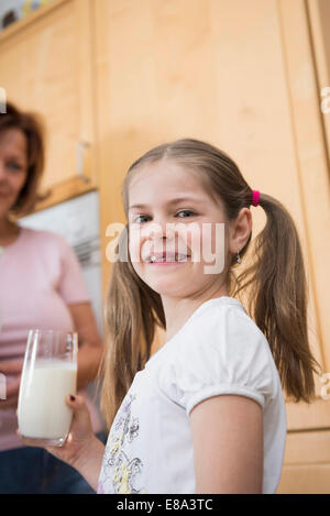 Nonna e nipote tenendo un bicchiere di latte, sorridente Foto Stock