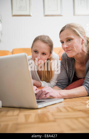 Madre e figlia utilizzando laptop, sorridente Foto Stock