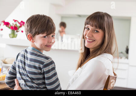 Ritratto di madre e figlio sorridere mentre l uomo in background Foto Stock