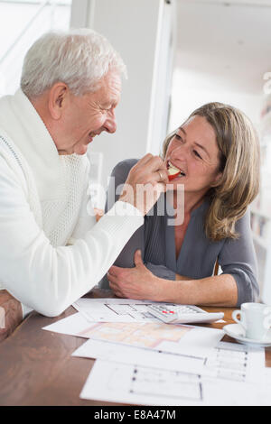 Felice senior alimentazione uomo donna con fette di mela Foto Stock