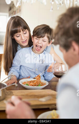 Famiglia giovane ragazzo mangiare spaghetti pranzo Foto Stock