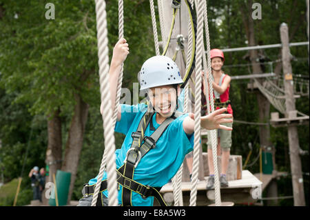 Un ragazzo e una ragazza climbing falesia, sorridente Foto Stock
