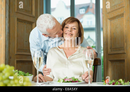 Uomo di baciare la moglie, sorridente Foto Stock