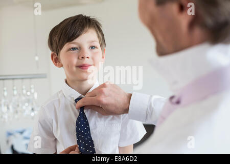 Padre figlio di regolazione di cravatta, sorridente Foto Stock