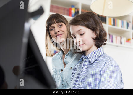Madre e figlia suonare il pianoforte, sorridente Foto Stock