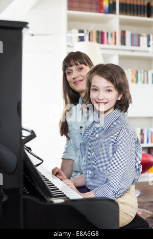 Madre e figlia suonare il pianoforte, sorridente Foto Stock