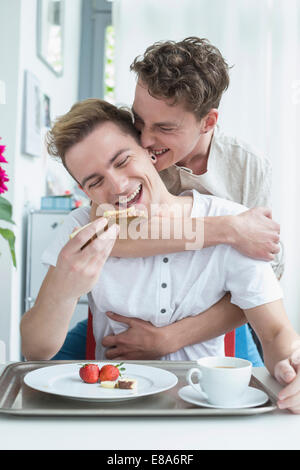 Coppia omosessuale avente colazione insieme sorridente Foto Stock