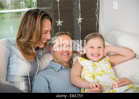 I genitori con la figlia seduta sul lettino divertendosi Foto Stock