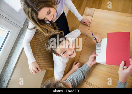Famiglia con modello architettonico a tavola Foto Stock