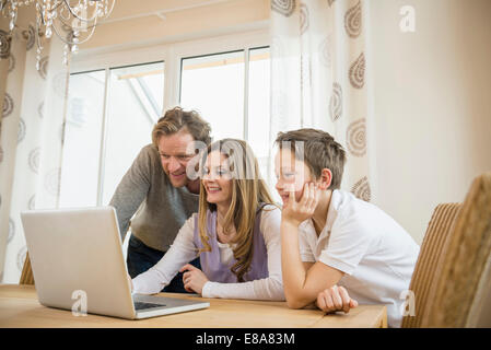 La famiglia tramite portatile a casa Foto Stock