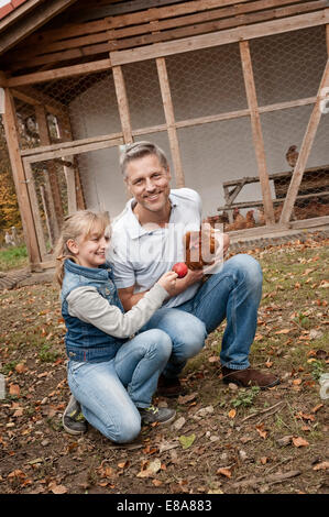 Padre e figlia con il pollo sul agriturismo biologico Foto Stock