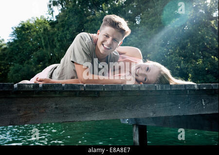 Giovane adolescente giacente su un pontile a lago Foto Stock