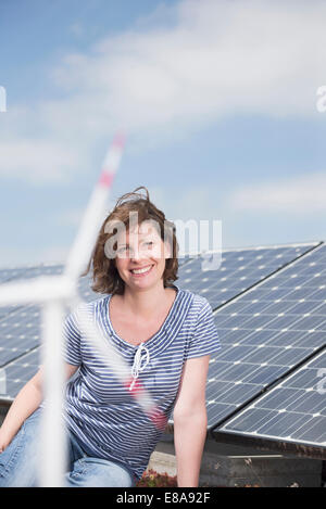 Ritratto di giovane donna pannello solare turbina eolica Foto Stock