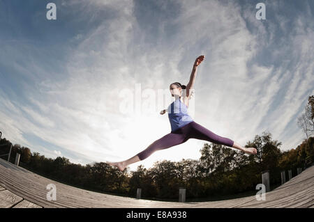 Donna jumpingmid aria, Woerthsee, Baviera, Germania Foto Stock