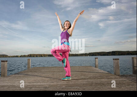 Woman Dancing Zumba sul molo, Woerthsee, Baviera, Germania Foto Stock