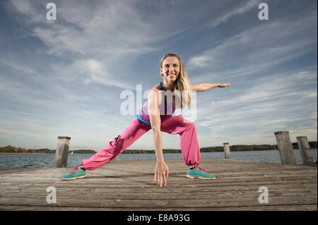 Woman Dancing Zumba sul molo, Woerthsee, Baviera, Germania Foto Stock