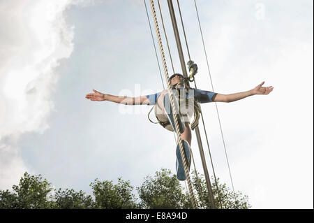 Adolescente di bilanciamento in una rupe di arrampicata Foto Stock