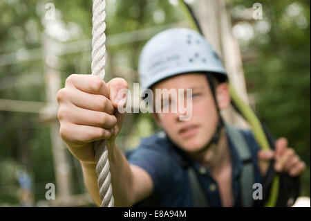 Adolescente in una rupe di arrampicata, close-up Foto Stock