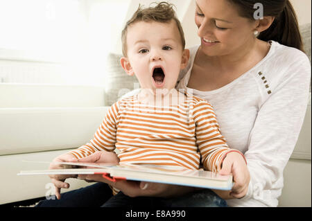 Madre e figlio sono guardando storybook, sorridente Foto Stock