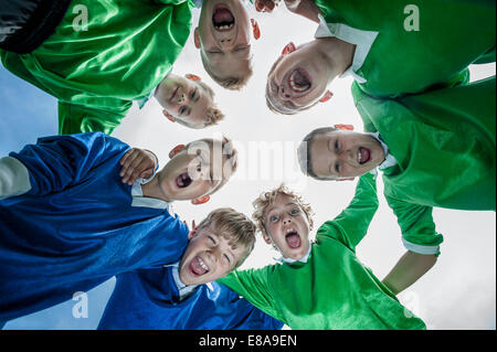 Junior Soccer team in huddle cerchio da sotto Foto Stock