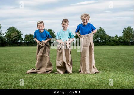 Tre giovani ragazzi preparando per sackrace Foto Stock