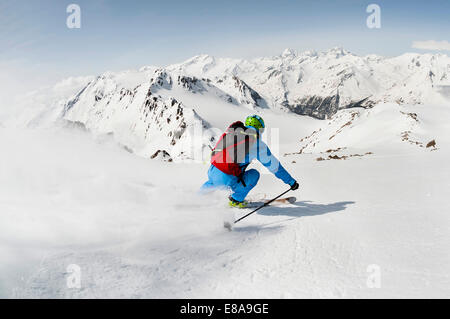 L'uomo sciatore sci discesa ripida pendenza montagne Foto Stock