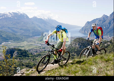 Gli uomini racing electic-mountainbike cliff valley Foto Stock