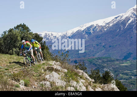 Due uomini racing electic-mountainbike cliff Foto Stock