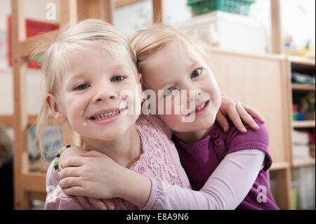 Ritratto di due bambine, migliori amici, fianco a fianco in una scuola materna Foto Stock