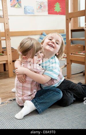 Bambina e little boy scatenandosi in kindergarten Foto Stock