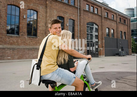 Teenage giovane seduto sulla bicicletta, sorridente Foto Stock