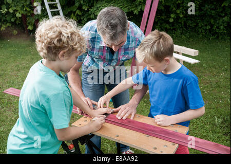 Padre figli giardino di lavoro la costruzione di legno Foto Stock