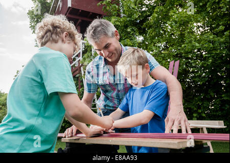 Il lavoro di squadra padre figli legno edificio di lavoro Foto Stock