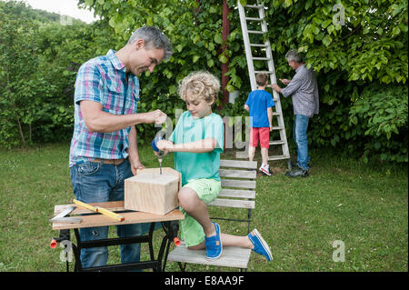 Padre nonno ragazzi birdhouse garden building Foto Stock