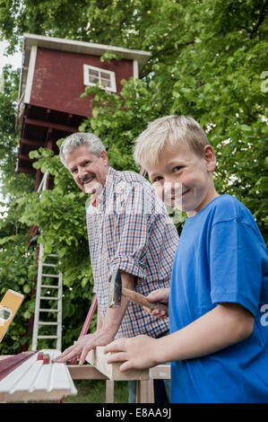 Nipote nonno lavorando insieme albero-house Foto Stock